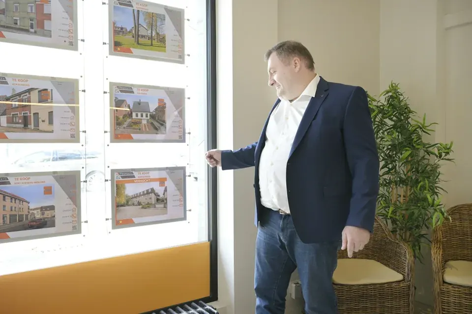 Oficina inmobiliaria con vidriera de propiedades y asesor